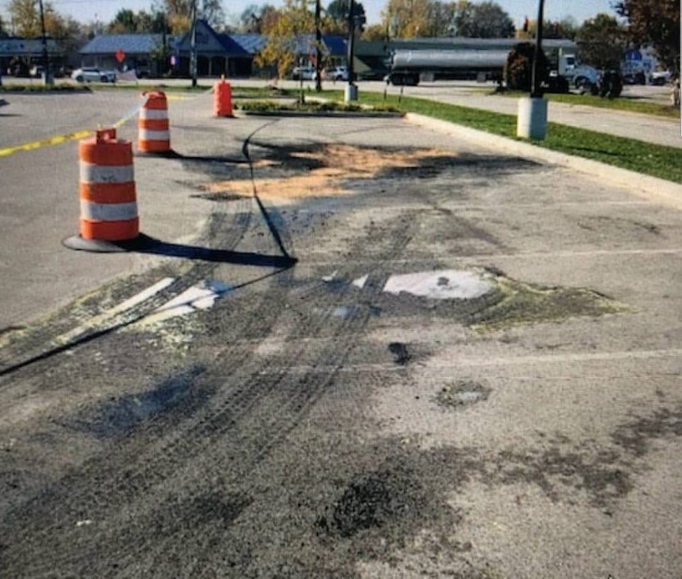 Commercial parking lot with burn scars and stains before pressure washing