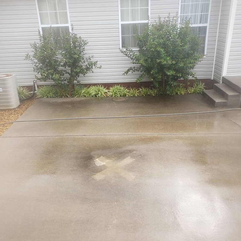 Rear concrete patio pad with grime before pressure washing