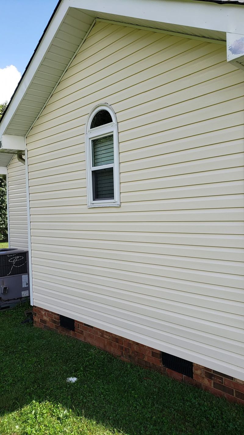 Same arch window area after soft washing — siding restored